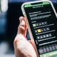 A hand holding a cellphone playing Wordle.